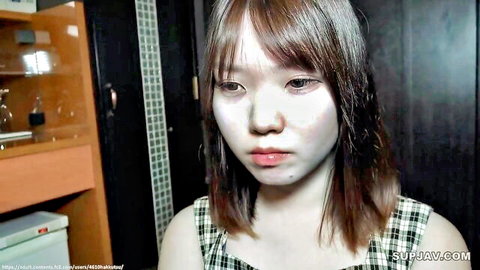 Young Asian woman with pale makeup and sad expression in checkered dress, JAV thumbnail