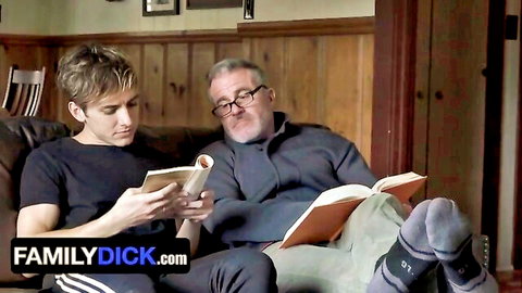 Glasses-wearing DILF stepdad and twink stepson reading books intimately on couch in taboo gay scene