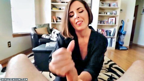 Brunette MILF smiles with thumbs up hand on big cock during POV handjob in living room