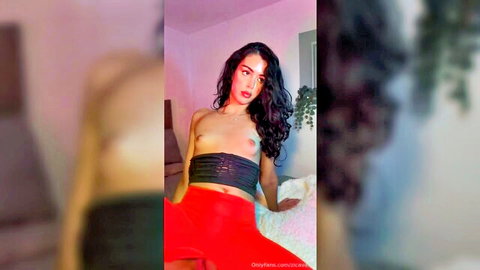 Brunette topless with black nipple tape over tits in red leggings teasing on bed