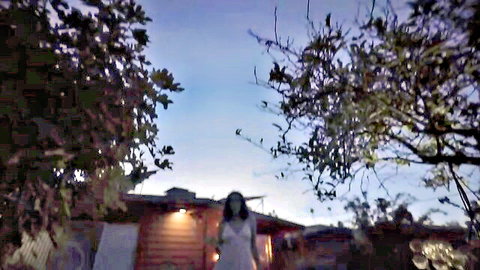 Sexy Caucasian woman in sheer white dress teasing outdoors at dusk with medium tits visible