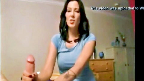 Brunette MILF in tight tank top gripping thick pink dildo smiling seductively