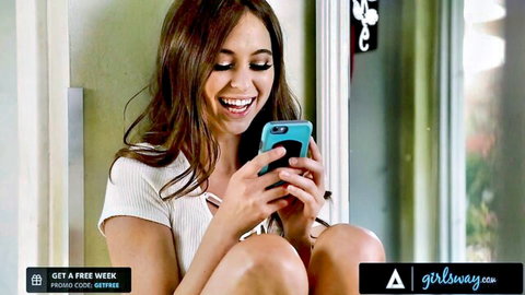 Riley Reid smiling teasingly on phone in white crop top, petite brunette tease