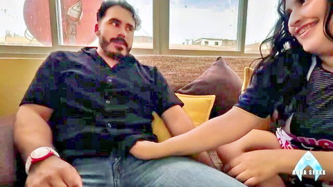 Latina BBW girlfriend with big tits smiles at boyfriend cuddling on couch amateur style