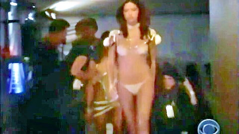 Skinny brunette in sheer lingerie exposing medium tits backstage with black men