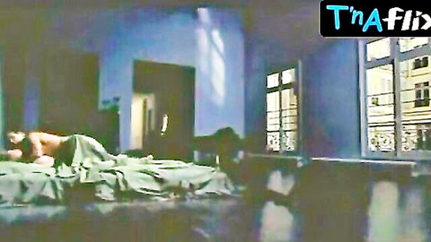 Muscular nude man lying topless in bed with sheet covering cock in blue bedroom