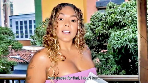 Busty curly-haired Latina MILF with huge tits spilling from low-cut top outdoors