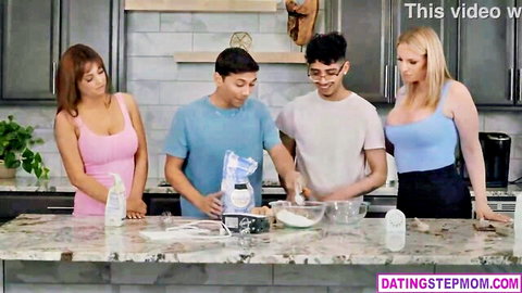 Busty brunette stepmom in pink top with blonde friend and stepsons in kitchen group scene
