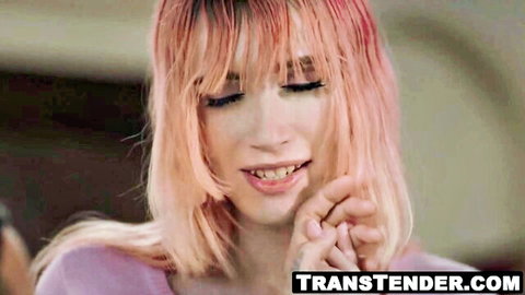 Pink-haired trans woman smiles seductively, teasing with fingers to lips
