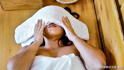 Topless Asian MILF with big tits lies blindfolded by towel in wooden sauna
