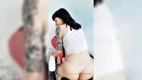 Petite tattooed babe in white tank top and pink thong exposing bare ass cheeks from behind