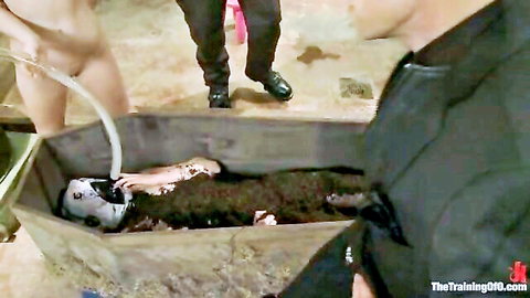 Partially nude body buried in muddy wooden coffin with police investigators nearby