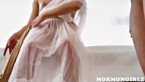Blonde woman in sheer white dress exposes herself seductively