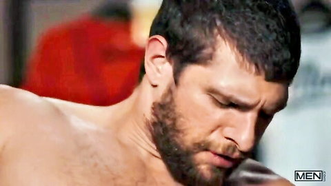 Bearded muscular hunk grimacing in intense pleasure during gay blowjob closeup