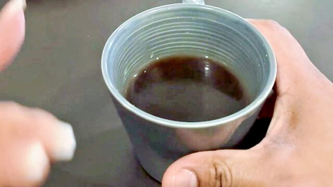 Brown hands adding sugar to coffee in blue mug, prelude to steamy encounter