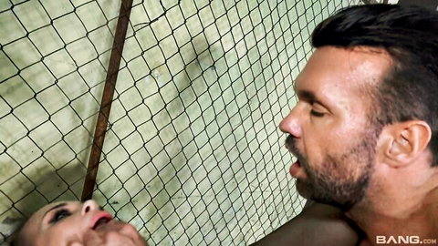 Luisa Star giving intense blowjob through chain link fence in BDSM