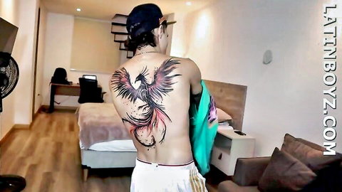 Latino hunk Fenix with phoenix tattoo, shirtless in white shorts
