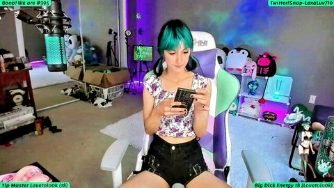 LexaLuv smiles with teal hair in floral blouse and black shorts, amateur solo tease