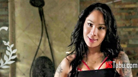 Sexy Asian MILF in red bra smiling teasingly in steamy bathtub