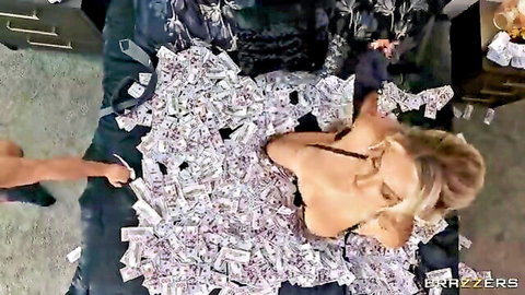 Blonde babe with huge tits lying topless on bed covered in stacks of cash as man grabs bills near her body