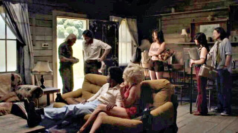 Brittany Snow in intimate couch cuddle with black man, surrounded by group