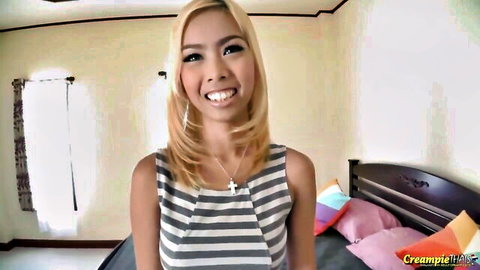 Slim Thai babe with blonde hair smiles in striped dress for creampie fun