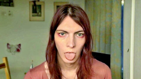 Redhead beauty with blank stare and tongue out in drooling fetish solo
