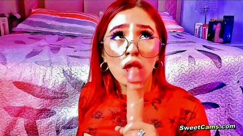 Red-haired Asian babe in glasses enjoys solo dildo oral play