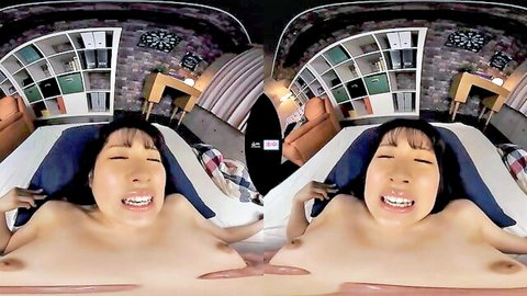 Smiling Asian teen with huge tits lying topless on bed in VR POV