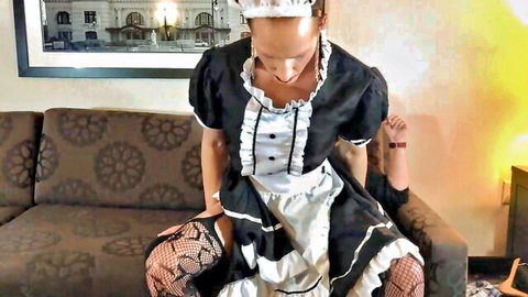 Sexy blonde maid in black uniform and lace stockings spreads legs wide on couch