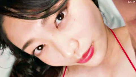 Seductive Asian brunette closeup with glossy red lips and red lingerie strap