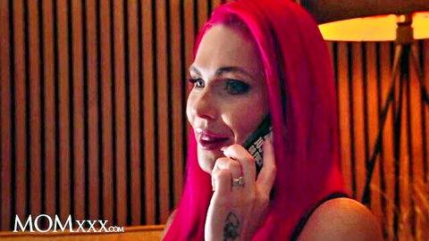 Roxi Keogh with pink hair on phone call, massive cleavage in black top