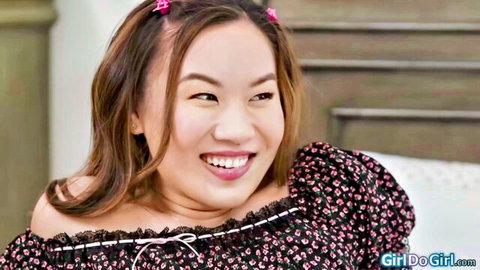 Smiling Asian stepmom in black floral off-shoulder top with pink hair clips