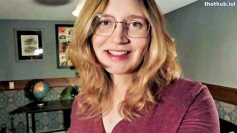 Smiling blonde MILF in glasses and maroon top teases solo on webcam