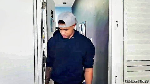 Muscular black college guy in hoodie and cap walks hallway in cuckold scene