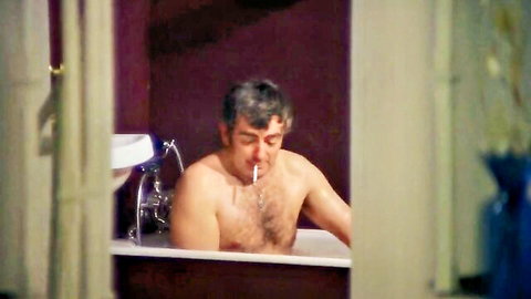 Vintage nude man smoking in bathtub from Poor Cow (1967) classic film