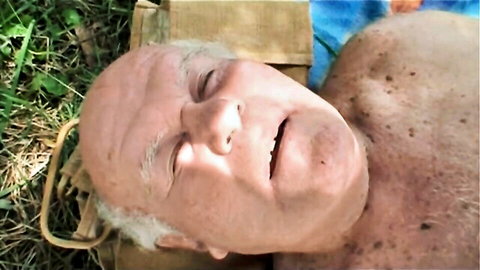 Smiling elderly man shirtless on outdoor blanket in old couple threesome preview