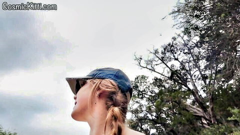 Blonde in blue cap on solo nudist beach, outdoor vlog experience