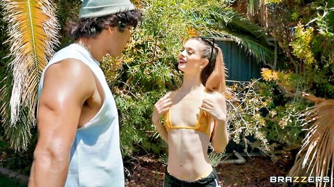 Petite bikini teen smiles naughtily hands on small tits teasing muscular hunk outdoors