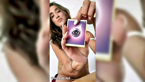 Brunette with deep cleavage holding purple eye tarot card selfie tease