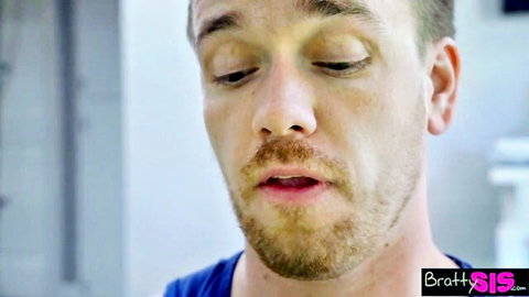 Handsome guy with mustache and goatee in blue shirt looks pleasured, mouth open during stepsis blowjob