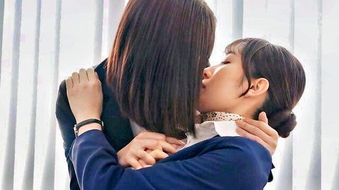 Two Asian women in suits passionately kissing