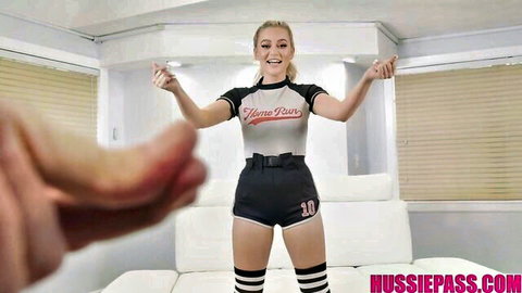 Smiling young blonde in tight Home Run jersey and short shorts poses teasingly with arms raised