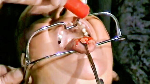 Submissive gagged with metal ring gag as red liquid forced into open mouth in BDSM humiliation