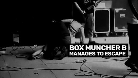 Band members performing on stage with guitars and amps during Box Muncher Escape show