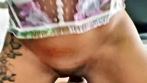 Tattooed woman in sheer purple lingerie exposing vulva and pubic hair, close-up with male penis nearby