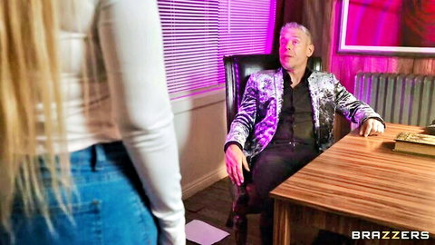 Blonde in tight blue jeans teases mature man in sequined jacket at office desk