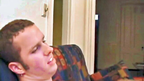 Ecstatic young guy with open mouth and flushed face reclining on colorful chair during intense pleasure