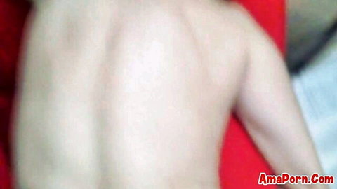 Pale mature woman nude from behind showing bare ass and back on red bed sheets
