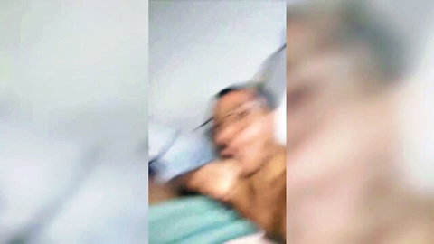 Blurry gay men embracing passionately on teal bed sheets